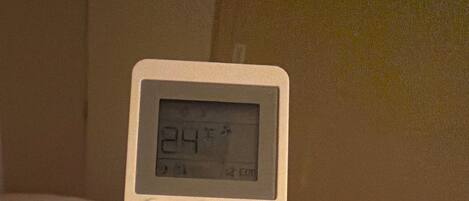 Une télécommande blanche de la marque BHI, dotée d’un écran numérique et de boutons pour les fonctions turbo, vitesse, mode, ainsi que pour les réglages tels que nettoyage, minuterie, mode silencieux et mode veille.