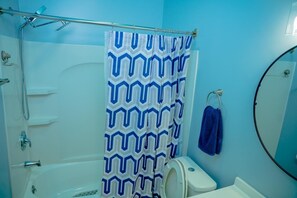A bathroom with a shower curtain, a toilet, a sink, and a mirror. - The Heaven Garden a 2-bedroom apartment in Huber Heights - Dayton the best spot. (Dayton)