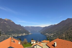 A mountainous landscape with a lake, houses with red-tiled roofs, and a clear sky. - Enchantment of the Lake - app. Bellagio Three-room apartment with A/C (Molina)