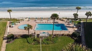A pool area with two pools, surrounded by palm trees and a view of the beach. - Oceanfront Escape | 2BR Condo | Private Beach Access + Resort Amenities (Saint Augustine)