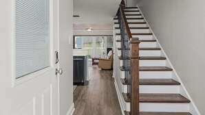 A staircase with wooden steps and metal railings, leading to an upper floor. - Oceanfront Escape | 2BR Condo | Private Beach Access + Resort Amenities (Saint Augustine)