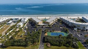 An aerial view of a coastal hotel with a beach view, multiple buildings, and a tennis court. - Oceanfront Escape | 2BR Condo | Private Beach Access + Resort Amenities (Saint Augustine)