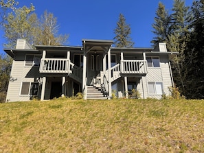 A two-story house with a front porch, a staircase, and a small garden area.