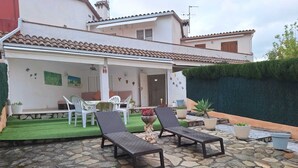 A patio with stone flooring, two lounge chairs, a table, and chairs. - Townhouse with pool in Benicasim 400 m from El Torreon beach (Benicàssim)
