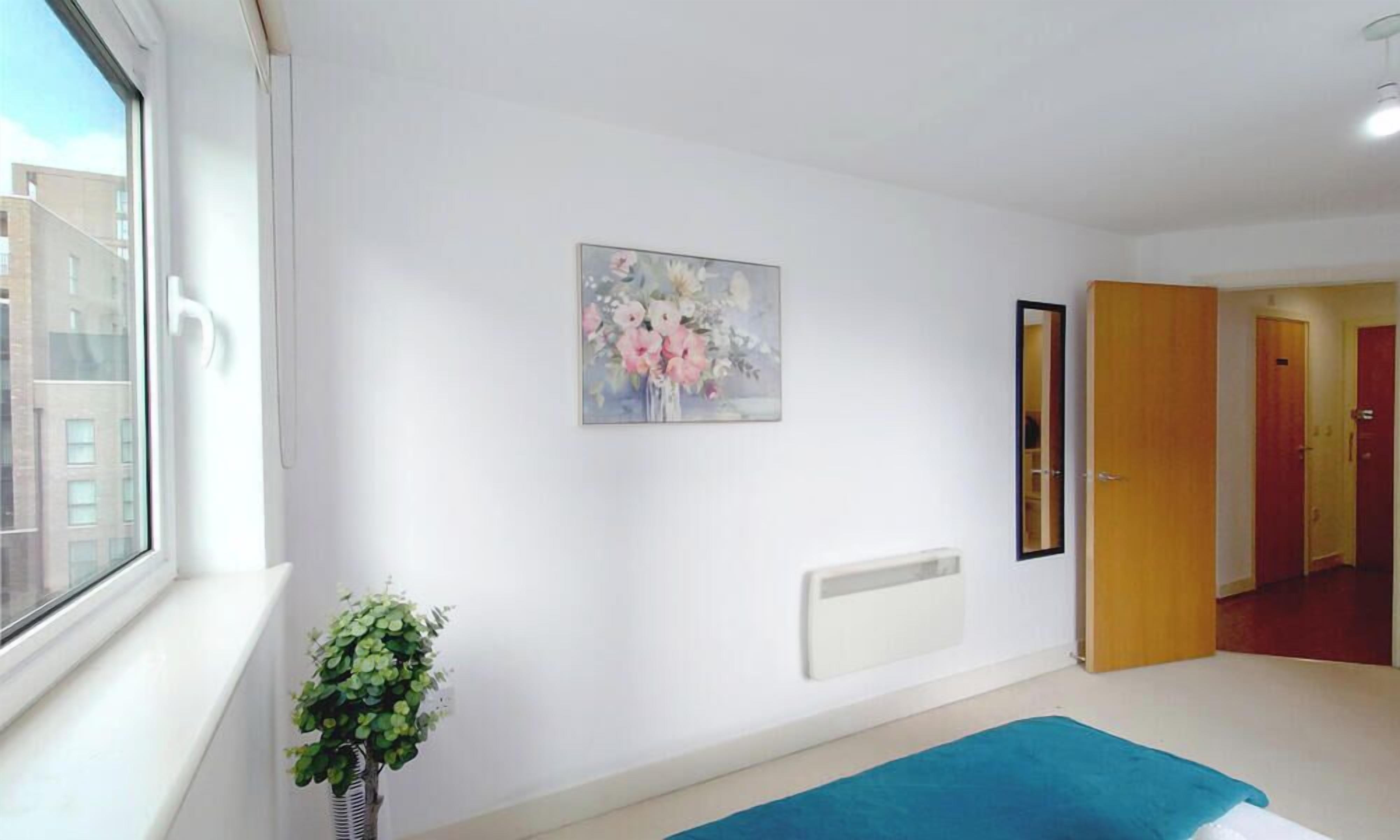 A room with a window, a radiator, a door, and a blue rug.