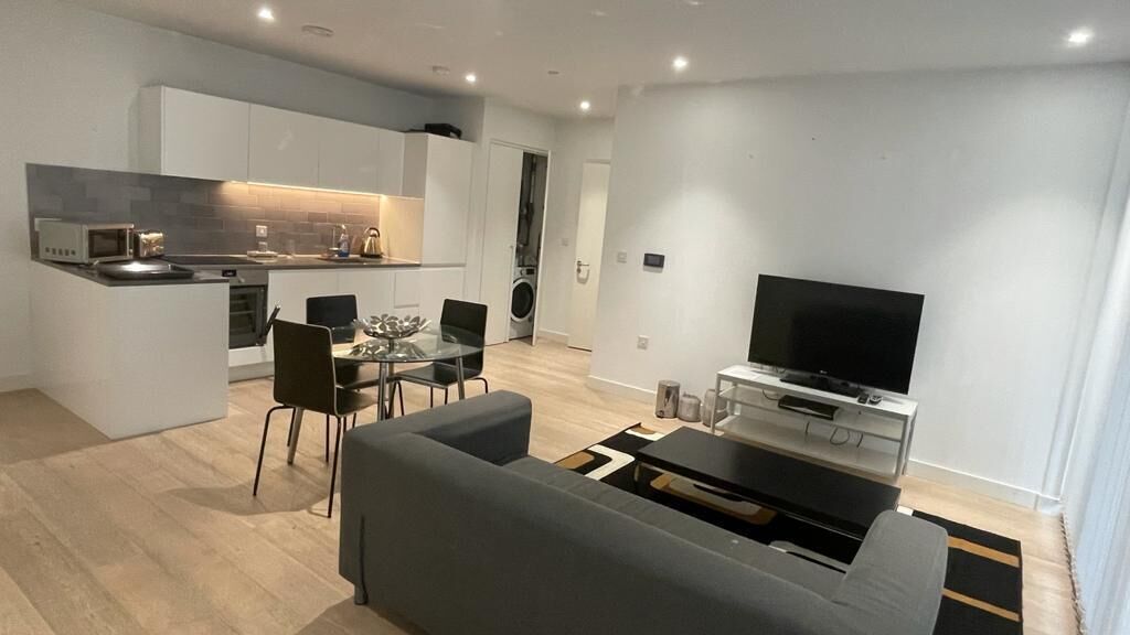 Un appartement moderne comprenant une cuisine, un coin repas et un salon.