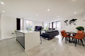 A modern living space with a kitchen island, dining area, and seating.