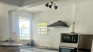 Une cuisine compacte dotée d’un îlot central, d’un four à micro-ondes, d’une cuisinière et d’un réfrigérateur.