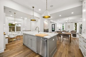 A modern kitchen with a central island, stainless steel appliances, and pendant lighting. - Elegant Home With Elevator @Med Center, MDAnderson, NRG, Rice University (Houston)