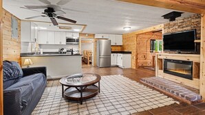 Una cocina moderna con armarios blancos, una isla central y un ventilador de techo.