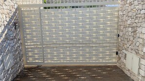 A gated area with a stone wall and a white fence. - Villa with Private Pool, Sea View in Sicily, Palermo-Terrasini. Family friendly (Serra)