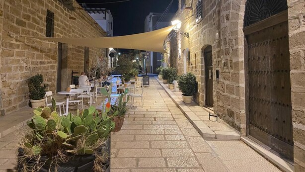 A courtyard with stone buildings, outdoor seating, and potted plants. - Villa with Private Pool, Sea View in Sicily, Palermo-Terrasini. Family friendly (Serra)