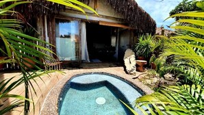 A thatched-roof building with a pool, surrounded by tropical plants. - Villa Fulô Casa Hotel (Porto Seguro)