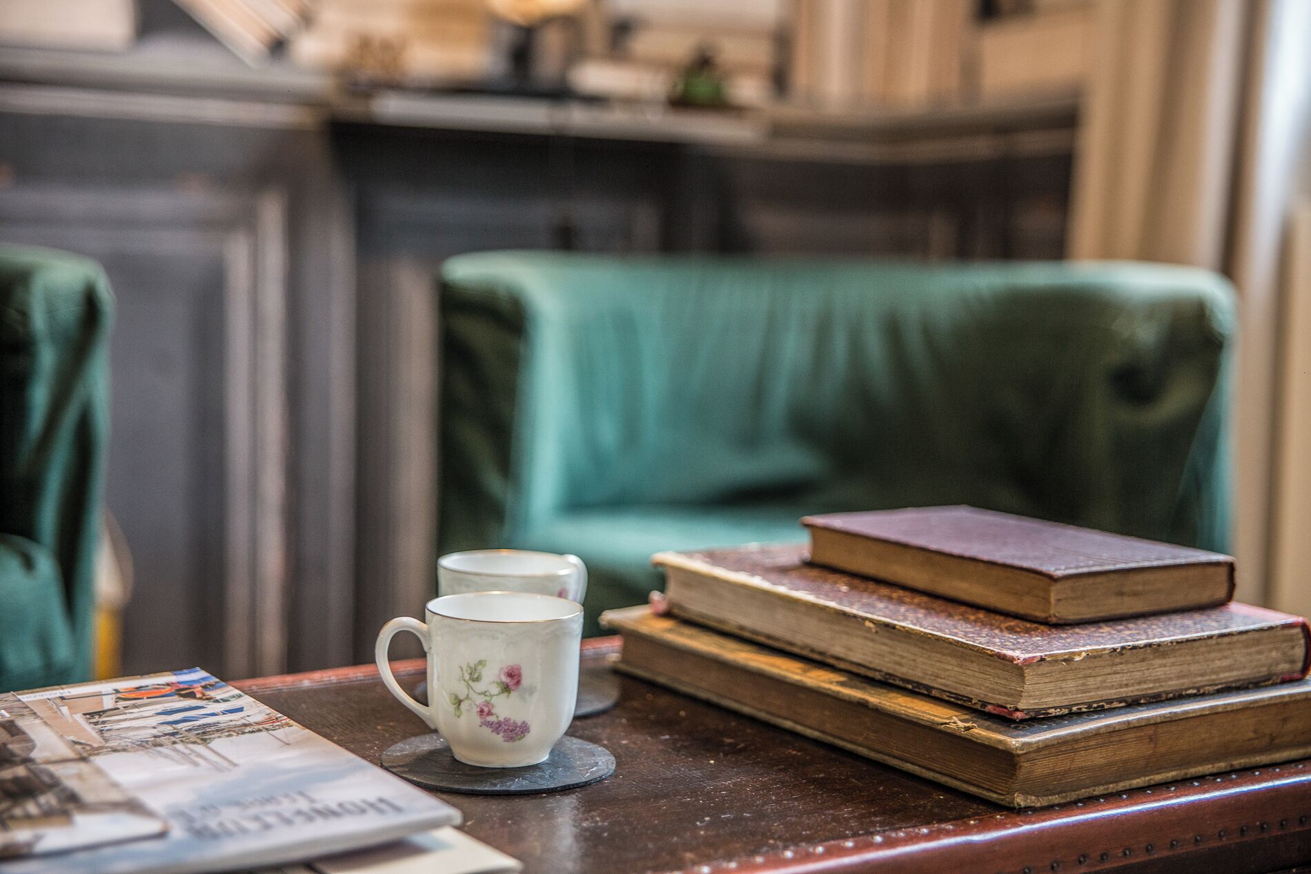 A table with a mug, books, and a magazine.