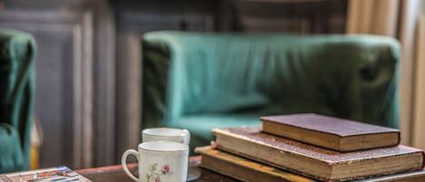 A table with a mug, books, and a magazine.