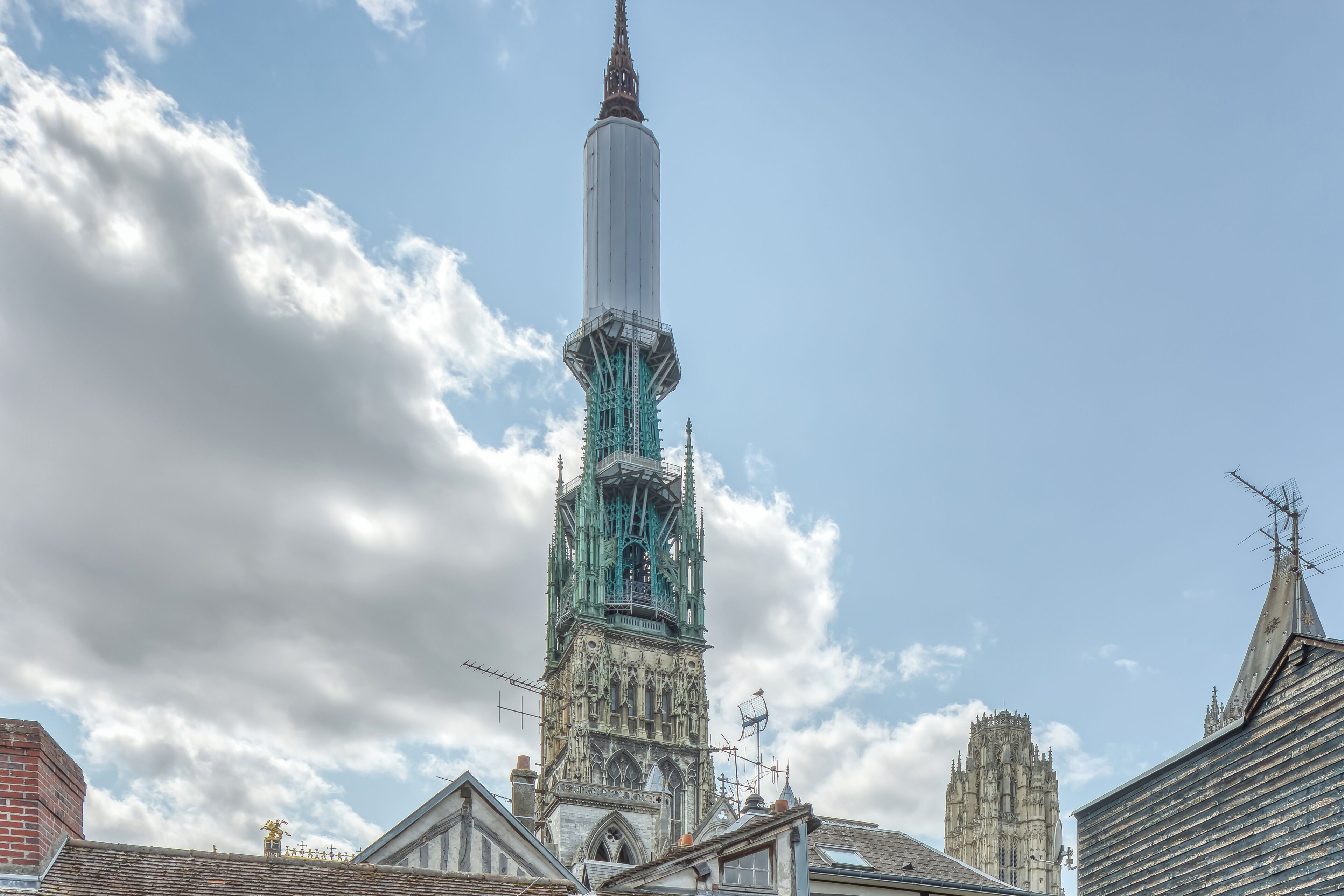 A historic tower with intricate architecture, a prominent spire, and a clock.
