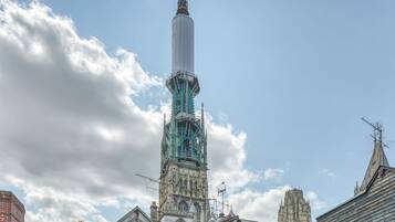 A historic tower with intricate architecture, a prominent spire, and a clock.