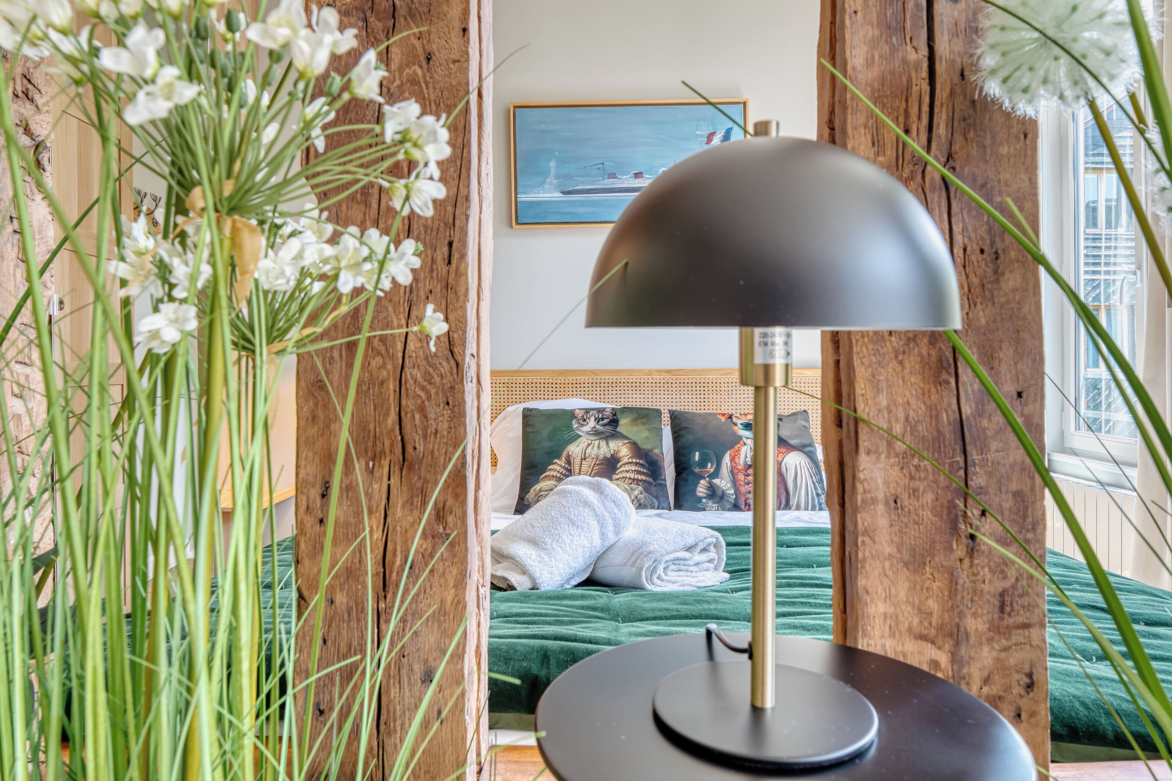 A room with a bed, a lamp, and a painting on the wall.