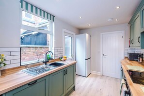 A kitchen with a window, sink, refrigerator, and cabinets. - Perfect Modern 4 Bed in Crewe, Great for Business (Cheshire East)