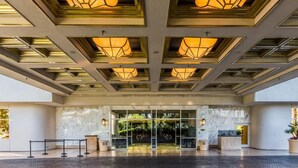 A hotel entrance with a modern design, featuring a glass door, a reception desk, and a patterned ceiling. - Stunning MGM Studio Strip View 16611 (Las Vegas)