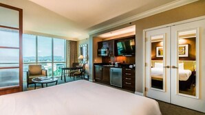 A hotel room with a large bed, a kitchenette, a dining area, and a view of the city. - Stunning MGM Studio Strip View 16611 (Las Vegas)