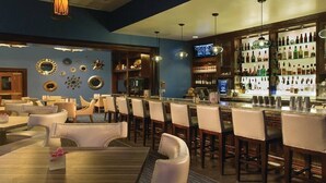 Un espace bar offrant différentes options de sièges, un comptoir et un écran de télévision.