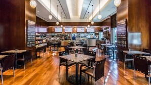 Ein geräumiges Restaurant mit mehreren Tischen, Stühlen, einer Bar und einer Theke.