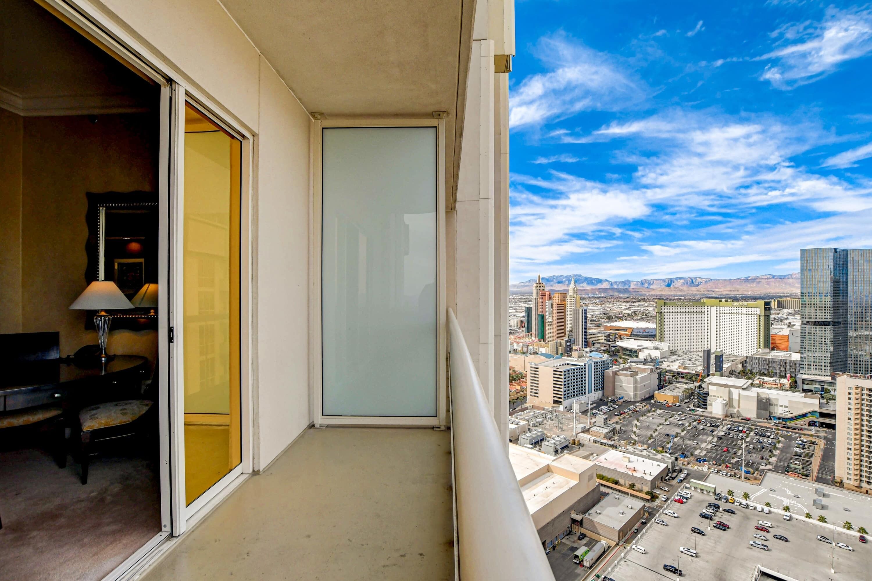Uma varanda com vista para a cidade, uma porta e um candeeiro.