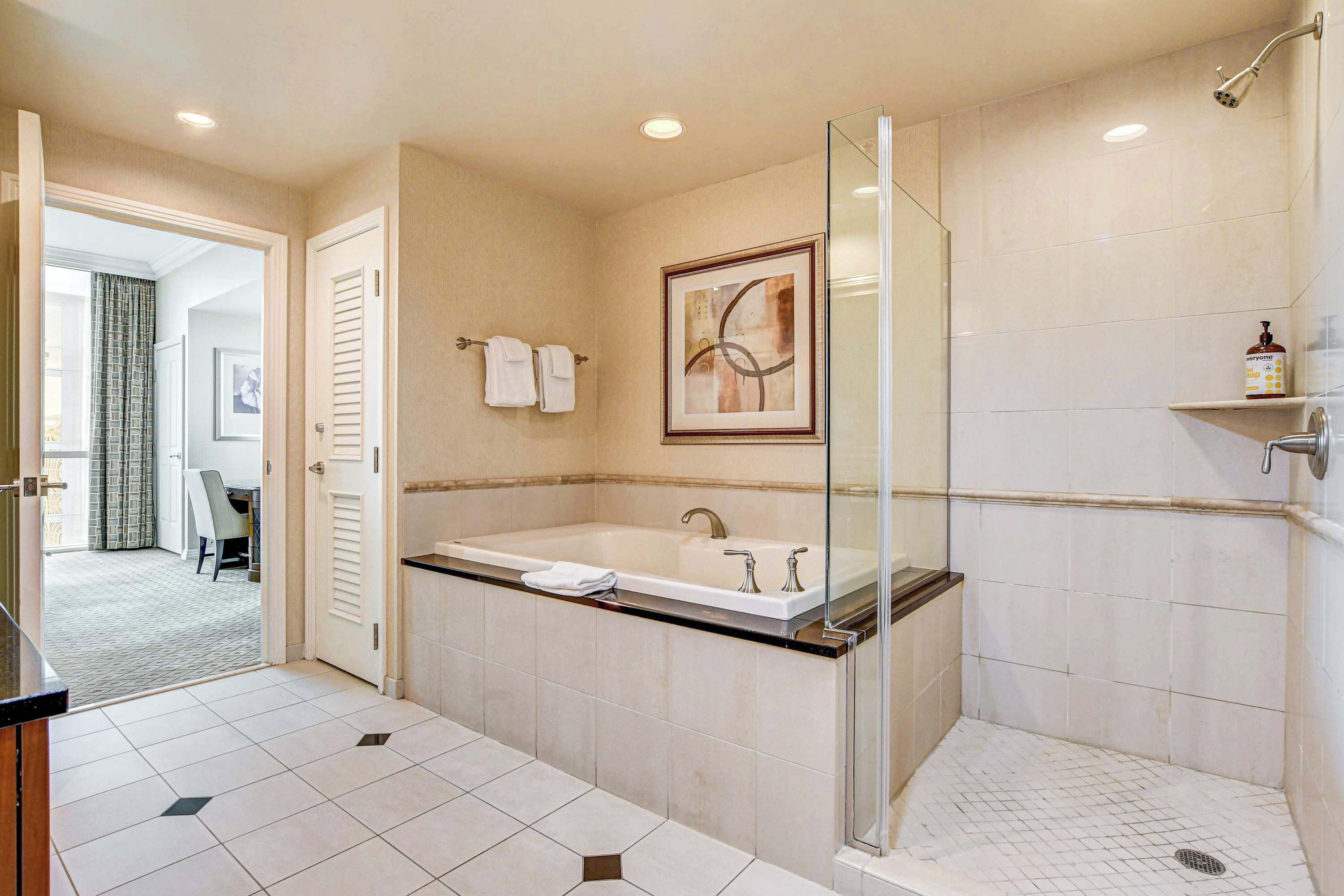 Un baño moderno con una bañera grande, una ducha con cerramiento de vidrio y suelo de baldosas.