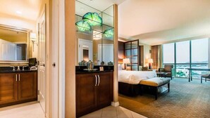 A hotel room with a bed, a desk, a chair, a large window, and a view of the city. - New* Stunning MGM Studio Strip View 10609 (Las Vegas)
