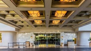 A hotel entrance with a modern design, featuring a glass door, a reception desk, and a patterned ceiling. - MGM 35719 Studio Strip View by Orgoto (Las Vegas)