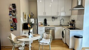 A modern kitchen with white cabinets, a dishwasher, a washing machine, and a coffee maker. - Do Padre - a relaxing vacation in the heart of Portugal - our "Lisbon Apartment" (Brogueira)