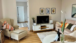 A living room with a sofa, armchair, TV, and decorative items. - Do Padre - a relaxing vacation in the heart of Portugal - our "Lisbon Apartment" (Brogueira)