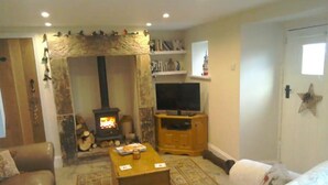 A cozy living room with a fireplace, a television, and comfortable seating. - Cosy Cottage Retreat. Log Burner. Courtyard & Starry Skies (Consett)