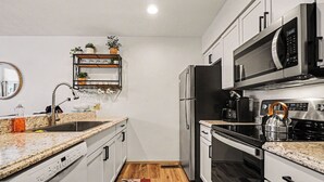 A compact kitchen with a microwave, refrigerator, stove, and dishwasher. - Spacious 2 bdrm, 2 Bath with Loft, 1500 Sq Ft. Many onsite amenities with Golf/Skiing near by! (Harbor Springs)