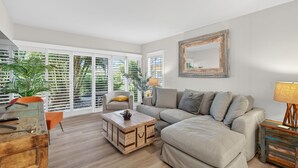 A living room with a sofa, a coffee table, a wooden chest, and a lamp. - Enjoyable 1-bedroom 1-bath condo in charming Marco Island. (Marco Island)