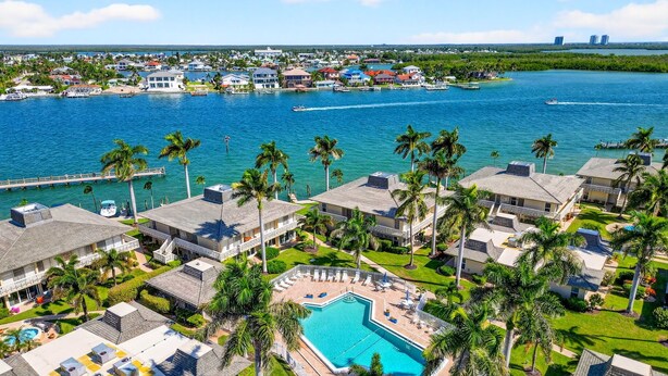 A resort with a central pool, multiple buildings, and a view of the ocean. - Enjoyable 1-bedroom 1-bath condo in charming Marco Island. (Marco Island)