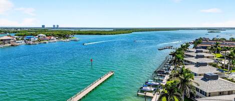 A coastal hotel with a marina, docked boats, and a pier extending into the water.