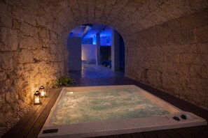 A spa area with a hot tub, stone walls, and a wooden deck. - Villa Rosa Resort - House 11 (Conversano)