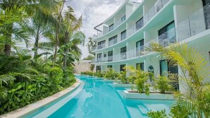 A modern hotel with a pool surrounded by lush greenery. - Jungle Vibes Studio in Tulum / Private (Tulum)