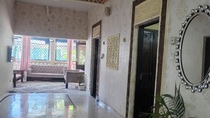A spacious room with a tiled floor, a ceiling fan, a large mirror, and a potted plant. - Luxurious 4-bedroom Holiday House With Pool Access in Diani Beach (Diani Beach)