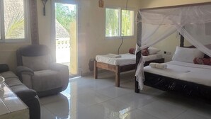 A hotel room with a bed, a chair, a small table, a ceiling fan, and a window with a view. - Luxurious 4-bedroom Holiday House With Pool Access in Diani Beach (Diani Beach)