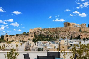 A view of ancient ruins and a classical temple on a hill, with modern buildings in the foreground. - Acropolis Propylaea Apartment by A&A Residencies  (Athens)