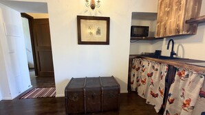 A kitchen with a wooden cabinet, a microwave, a sink, and a framed picture on the wall. - Enchantment of the Lake app Menaggio two-room apartment with bathroom and balcony (Molina)