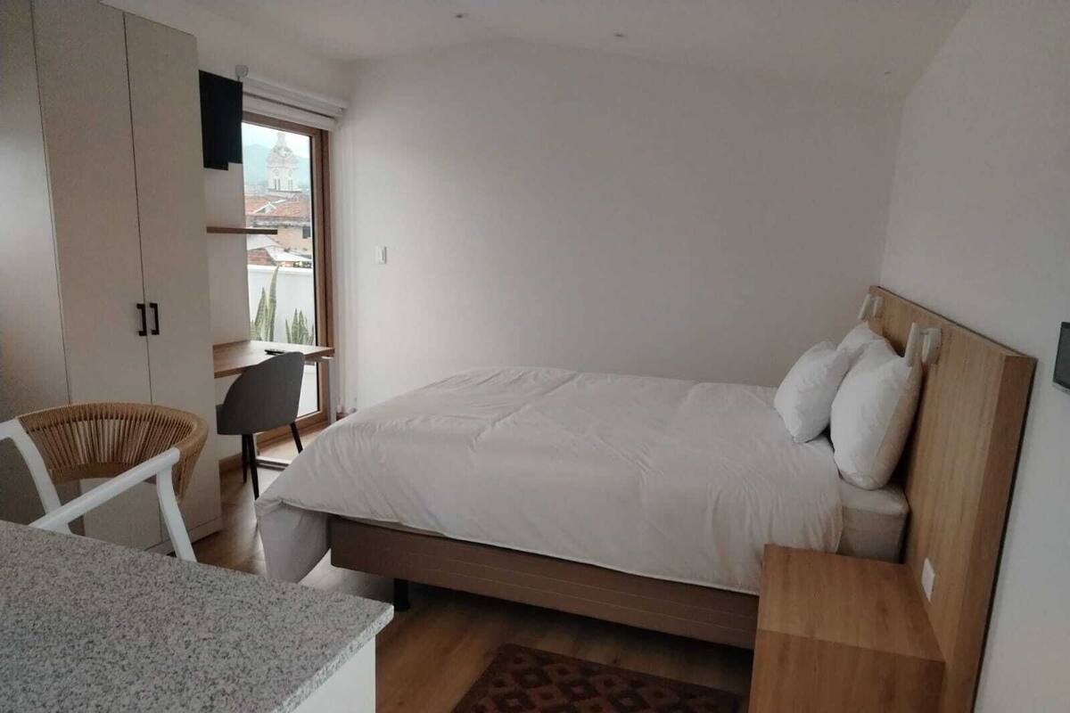 Ein Schlafzimmer mit Bett, Schreibtisch, Stuhl und Kleiderschrank.
