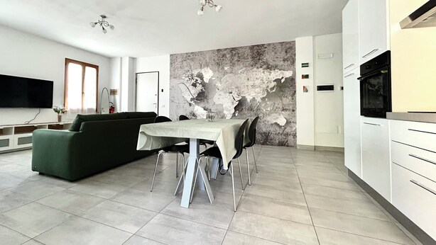 A modern living room with a dining table, sofa, and kitchen area. - Spring House - The porch .... For a relaxing vacation (Valeggio sul Mincio)