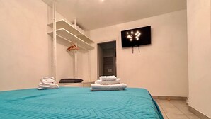 A hotel room with a large bed, a flat-screen TV mounted on the wall, and a towel rack with folded towels. - Spring House - The porch .... For a relaxing vacation (Valeggio sul Mincio)