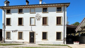 A two-story building with a symmetrical facade, multiple windows, and a central entrance. - Spring House - The porch .... For a relaxing vacation (Valeggio sul Mincio)