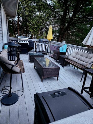 Une terrasse dotée de mobilier d’extérieur, d’un barbecue et d’une lanterne.