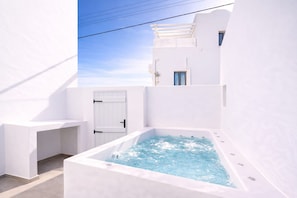 A white building with a hot tub, a door, and a window. - Iliana s Getaway - Private Villa With Jacuzzi (Santorini)